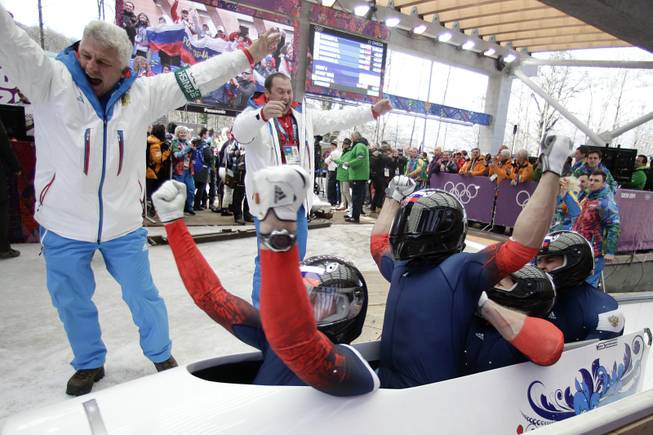 The team from Russia RUS-1, with Alexander Zubkov, Alexey Negodaylo, Dmitry Trunenkov, and Alexey Voevoda, celebrate after they won the gold medal during the men's four-man bobsled competition final at the 2014 Winter Olympics, Sunday, Feb. 23, 2014, in Krasnaya Polyana, Russia.