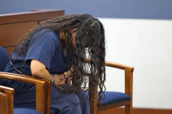 Elinor Indico, accused of stabbing her pregnant sister-in-law to death, hangs her head during a hearing at the Regional Justice Center Monday, Feb. 24, 2014.