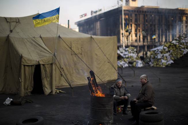Opposition supporters warm themselves around a fire in Kiev's Independence Square, the epicenter of the country's current unrest, Ukraine, Monday, Feb. 24, 2014.