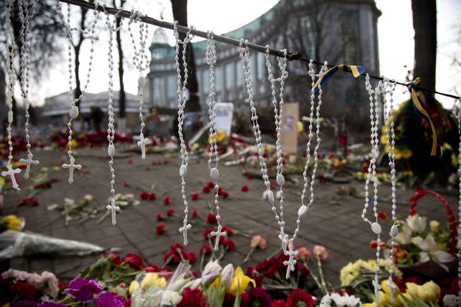 Rosary beads hang on a barricade in Kiev's Independence Square, the epicenter of the country's current unrest, Ukraine, Monday, Feb. 24, 2014. 