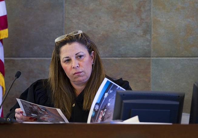 Judge Abbi Silver looks over crime scene photos during a trial for Armando Vergara-Martinez at the Clark County Regional Justice Center Tuesday, Feb. 25, 2014. Martinez is accused of attacking Maria Gomez with a machete in the parking lot of a North Las Vegas convenience store in 2012.