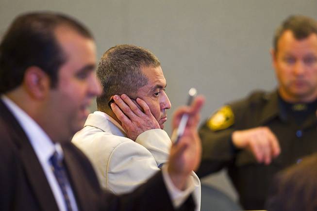 Armando Vergara-Martinez, center, listens to a Spanish interpreter through an earphone during his trial at the Clark County Regional Justice Center Tuesday, Feb. 25, 2014. Martinez is accused of attacking Maria Gomez with a machete in the parking lot of a North Las Vegas convenience store in 2012.