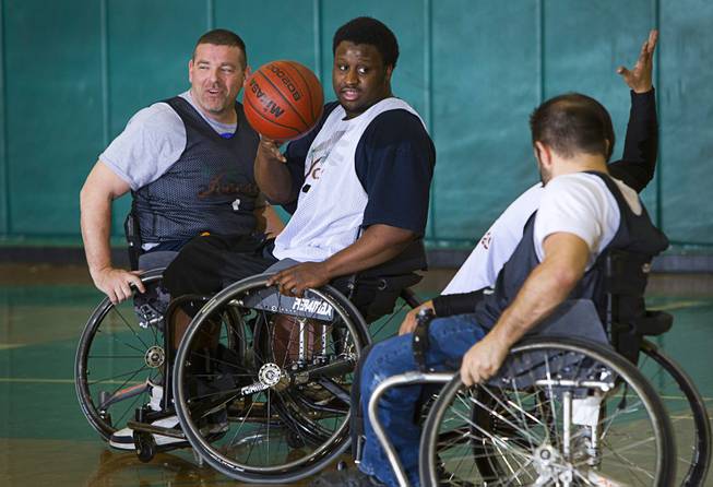 Marc Fenn, left, Timothy Oliver, center, and other wheelchair basketball team members practice at Rancho High School Tuesday, Feb. 25, 2014. The team is practicing for a scrimmage against a Wounded Warriors team at Nellis Air Force Base on Thursday.