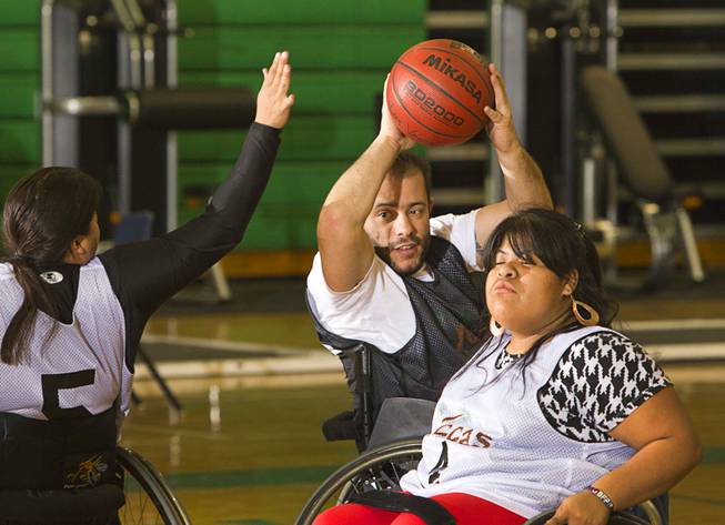 Mike Humel, center, practices with Steven Morales, left, and Cinthya Huendo at Rancho High School Tuesday, Feb. 25, 2014. The wheelchair basketball team is practicing for a scrimmage against a Wounded Warriors team at Nellis Air Force Base on Thursday.