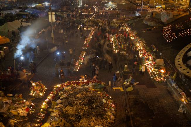 People light cantles and place flowers at a memorial for the people killed in clashes with the police at Kiev's Independence Square, the epicenter of the country's current unrest, Ukraine, Tuesday, Feb. 25, 2014. 