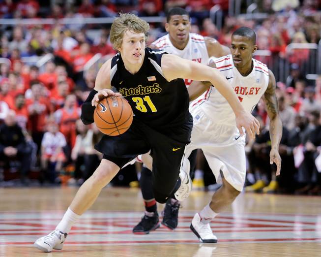Wichita State guard Ron Baker (31) pushes down the court past the defense of Bradley guard Ka'Darryl Bell (0) during the first half of an NCAA college basketball game at Carver Arena, Tuesday, Feb. 25, 2014, in Peoria, Ill. 