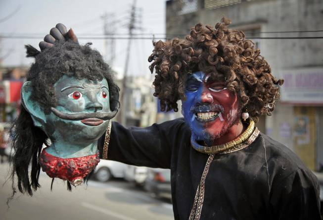 A Hindu devotee dressed as a demon participates in a procession on the eve of Shivratri festival, in Jammu, India, Wednesday, Feb. 26, 2014. 