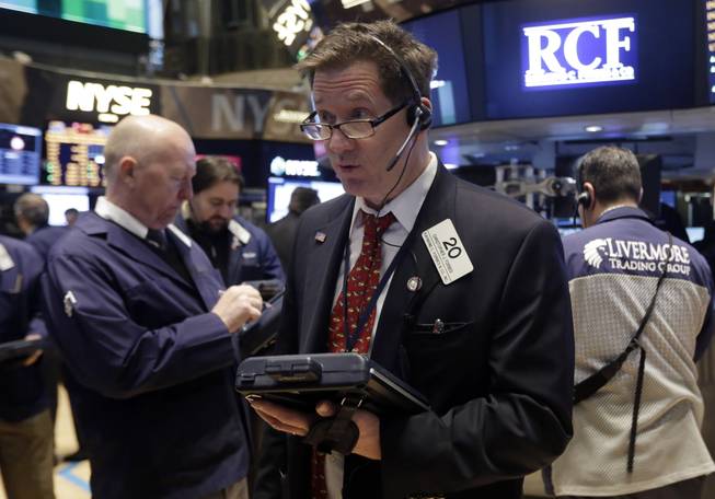In this Wednesday, Feb. 26, 2014, file photo, Trader Christopher Forbes, center, works on the floor of the New York Stock Exchange.