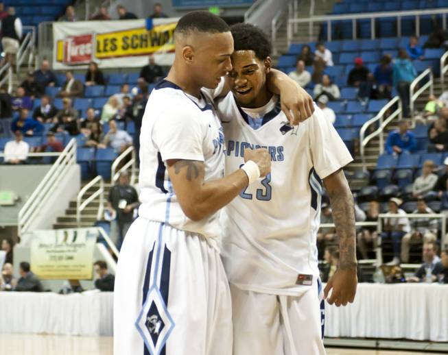 Shaquille Carr, right, shares a hug with a teammate after the final buzzer Thursday, Feb. 27, 2014 as Canyon Springs defeats Spanish Springs 66-51 in the semifinals of the Nevada State Championships at Lawlor Events Center in Reno.