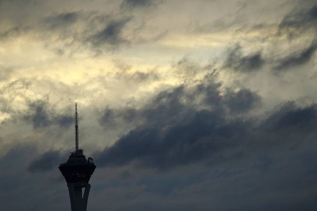 The Stratosphere Tower is silhouetted by a break in the clouds and the setting sun during the afternoon Friday, Feb. 28, 2014.