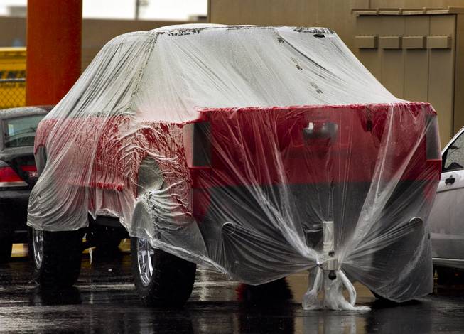 A newly painted vehicle is wrapped in plastic to keep it dry during a rainy day in Las Vegas on Friday, Feb. 28, 2014.