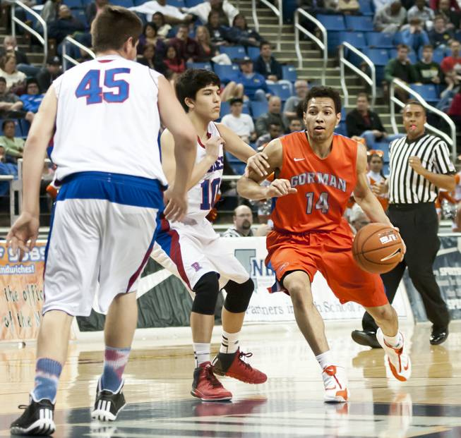 Noah Robotham knifes through the lane between defenders Thursday, Feb. 27, 2014 as Bishop Gorman defeats Reno 68-27 in the semifinals of the Nevada State Championships at Lawlor Events Center in Reno.