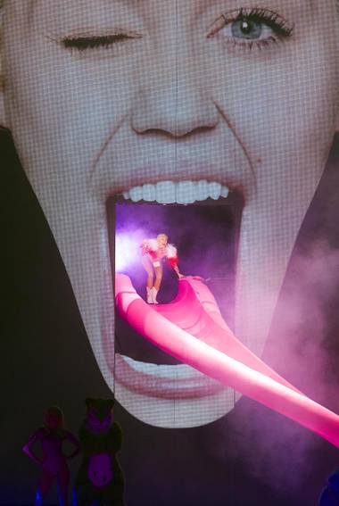Miley Cyrus arrives on a slide to the stage at MGM Grand Garden Arena on Saturday, March 1, 2014, in Las Vegas.