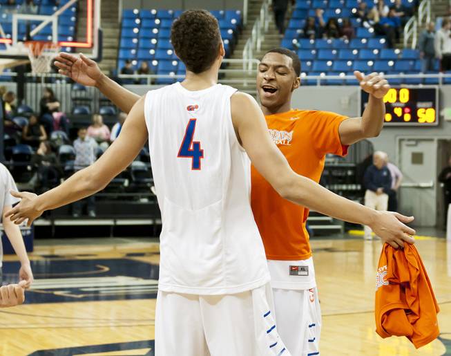 Bishop Gorman teammates celebrate after the final buzzer Friday, Feb. 28, 2014 as Bishop Gorman defeated Canyon Springs 71-58 in the Nevada state championship game at Lawlor Event Center in Reno.