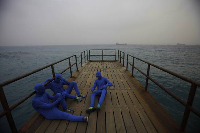 Men in the blue costumes are seen at a pier during the traditional parade to mark the end of the carnival period, in the southern port city of Limassol, southern of capital Nicosia, Cyprus, Sunday, March 2, 2014. Thousands of people gather every year to celebrate the Carnival in the streets.  