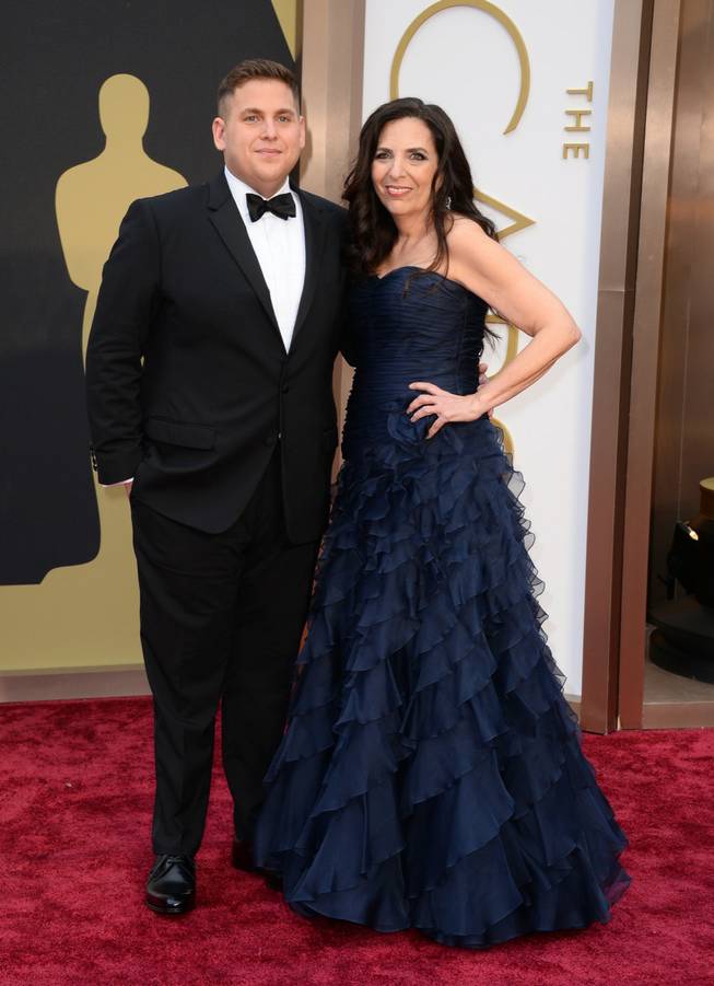 Jonah Hill, left, and Sharon Lyn Chalkin arrive at the Oscars on Sunday, March 2, 2014, at the Dolby Theatre in Los Angeles.  (Photo by Jordan Strauss/Invision/AP)
