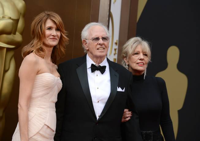 From left, Laura Dern, Bruce Dern and Andrea Beckett arrive at the Oscars on Sunday, March 2, 2014, at the Dolby Theatre in Los Angeles.  (Photo by Jordan Strauss/Invision/AP)