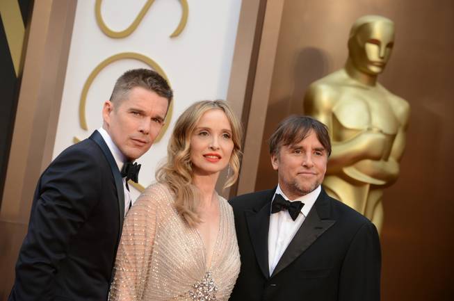 From left, Ethan Hawke, Julie Delpy and Richard Linklater arrive at the Oscars on Sunday, March 2, 2014, at the Dolby Theatre in Los Angeles.  (Photo by Jordan Strauss/Invision/AP)