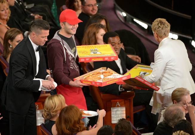 Brad Pitt, left, and Ellen DeGeneres, right, pass out pizza in the audience during the Oscars at the Dolby Theatre on Sunday, March 2, 2014, in Los Angeles.  (Photo by John Shearer/Invision/AP)