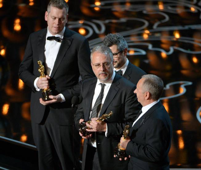 Christopher Benstead, Niv Adiri, Skip Lievsay, and Chris Munro accept the award for best sound mixing for "Gravity" during the Oscars at the Dolby Theatre on Sunday, March 2, 2014, in Los Angeles.  (Photo by John Shearer/Invision/AP)