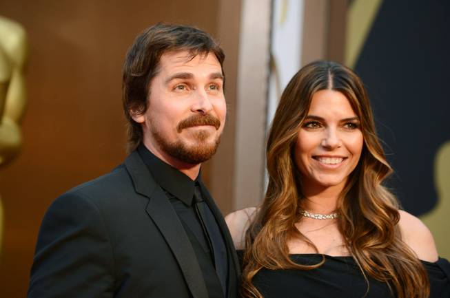 Christian Bale, left, and Sibi Blazic arrive at the Oscars on Sunday, March 2, 2014, at the Dolby Theatre in Los Angeles.  (Photo by Jordan Strauss/Invision/AP)