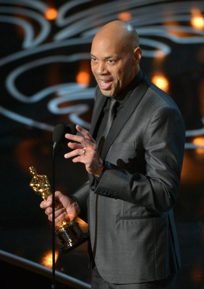 John Ridley accepts the award for the best adapted screenplay of the year for "12 Years a Slave" during the Oscars at the Dolby Theatre on Sunday, March 2, 2014, in Los Angeles.  (Photo by John Shearer/Invision/AP)