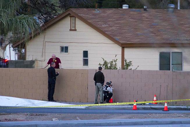 Metro Police investigators and a Metro crime scene analyst work the scene of an officer-involved shooting by Charleston Boulevard and Highway 95 Monday, March 3, 2014.