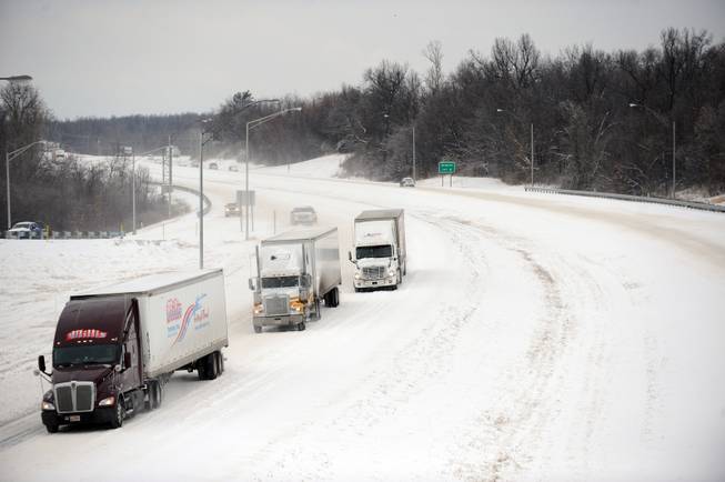 Tractor trailer cautiously travel along Interstate 24 Monday, March 3, 2014, in Paducah, Ky. A winter storm brought ice, sleet and snow to the region hampering travel and business. Area colleges, school and shopping centers have closed. 