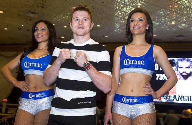 Light middleweight boxer Canelo Alvarez of Mexico poses with Corona Girls in the MGM Grand lobby Tuesday, March 4, 2014. Alvarez will face Alfredo Angulo, also of Mexico, in a non-title, 12-round fight at the MGM Grand Garden Arena on Saturday.