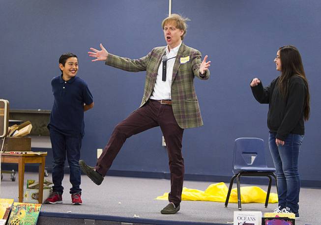 Comedy-magician Mac King gets help with a trick from Ryan Escobar and Jazlynn Valdez as he kicks off his Magical Literacy Tour: Nevada Reading Week 2014 with students at Vegas Verdes Elementary School Tuesday, March 4, 2014. For the fourth year, the Harrahs headliner will visit schools to perform magic tricks, talk about the importance of reading and distribute books collected during book drives.