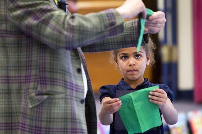 Kindergartener Dariah Tubbs tries to copy comedy-magician Mac King as he makes an origami hat during his Magical Literacy Tour: Nevada Reading Week 2014 with students at Vegas Verdes Elementary School Tuesday, March 4, 2014. For the fourth year, the Harrahs headliner will visit schools to perform magic tricks, talk about the importance of reading and distribute books collected during book drives.