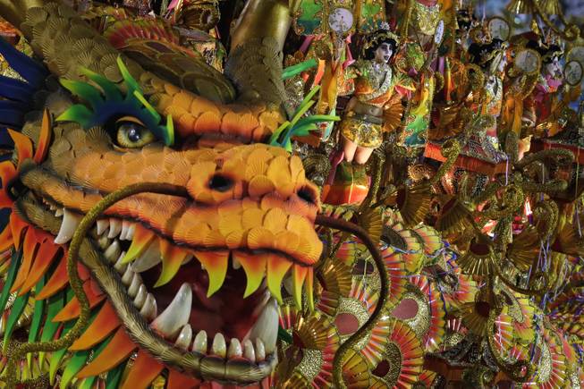 Performers from the Beija Flor samba school parade on a float during carnival celebrations at the Sambadrome in Rio de Janeiro, Brazil, Monday, March 3, 2014. 