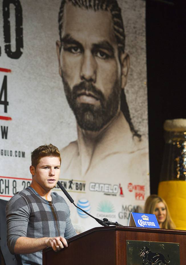 Super welterweight boxer Canelo Alvarez speaks during a news conference at the MGM Grand Thursday, March 6, 2014. Alvarez and Alfredo Angulo, both of Mexico, will fight at the MGM Grand Garden Arena on Saturday. An image of Angulo is shown on a banner behind Alvarez.