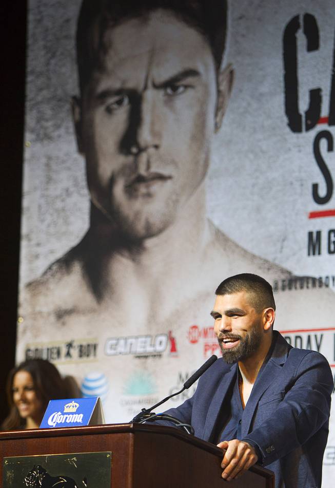 Super welterweight boxer Alfredo Angulo speaks during a news conference at the MGM Grand Thursday, March 6, 2014. Angulo and Canelo Alvarez, both of Mexico, will fight at the MGM Grand Garden Arena on Saturday. An image of Alvarez is shown on a banner behind Angulo.