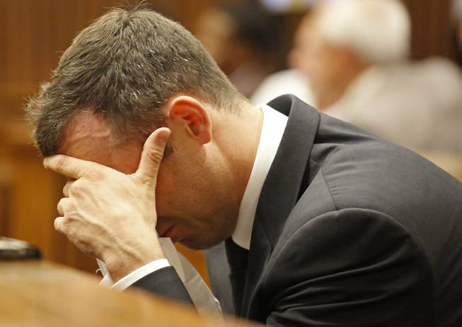 Oscar Pistorius puts his hand to his face as he listens to cross questioning about the events surrounding the shooting death of his girlfriend Reeva Steenkamp, in court during his trial in Pretoria, South Africa, Friday, March 7, 2014.