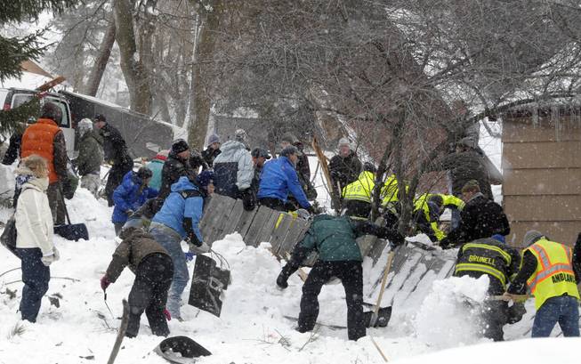 Rescuers dig frantically at the scene of an avalanche in Missoula's Rattlesnake Valley on Friday, Feb. 28, 2014, looking for a boy buried in the snow.