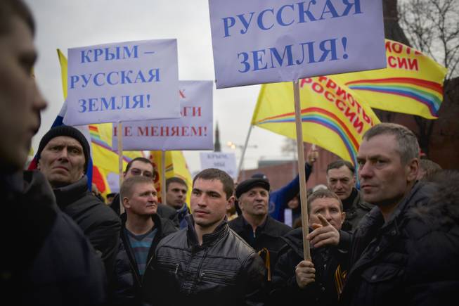 Pro-Putin demonstrators hold posters reading "Crimea is Russian land!" as they gather towards to Red Square in Moscow, Russia, Friday, March 7, 2014.