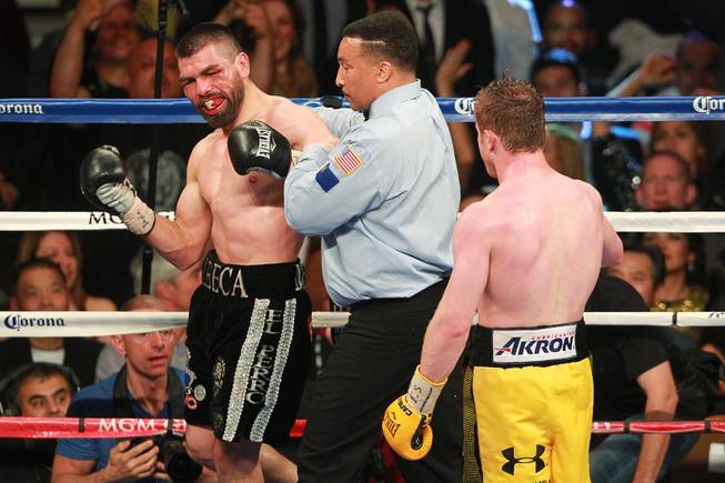 Referee Tony Weeks pushes Alfredo Angulo away from Saul "Canelo" Alvarez as he calls the fight off in the 10th round Saturday, March 8, 2014 at the MGM Grand Garden Arena.