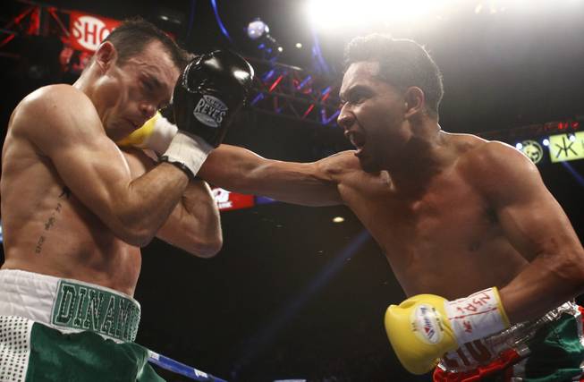 Ricardo Alvarez, left, takes a punch from Sergio Thompson, both of Mexico, during their lightweight fight at the MGM Grand Garden Arena on Saturday, March 8, 2014. Ricardo Alvarez is the brother of Canelo Alvarez. 