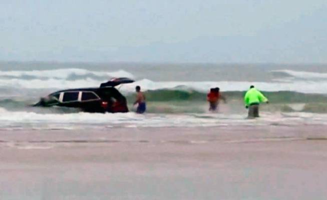 In this image made from video and released by Simon Besner, lifeguards rescue children from a minivan that their mother drove into the Atlantic Ocean on Tuesday, March 4, 2014, in Daytona Beach, Fla. Ebony Wilkerson, 31, a pregnant South Carolina woman who drove a minivan carrying her three young children into the ocean surf off Florida had talked about demons before leaving the house, according to her sister.