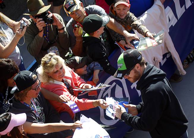 Dale Earnhardt Jr. signs autographs after a drivers meeting before the Kobalt 400 NASCAR Sprint Cup Series race at the Las Vegas Motor Speedway Sunday, March 9, 2014. Earnhardt was leading the race on the final lap but ran out of fuel and was passed by Brad Keselowski.