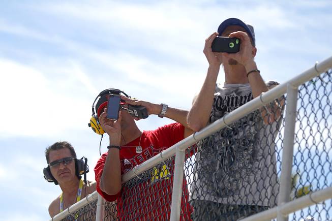 Fans take video on their phones during the Kobalt 400 NASCAR Sprint Cup Series race at the Las Vegas Motor Speedway Sunday, March 9, 2014.