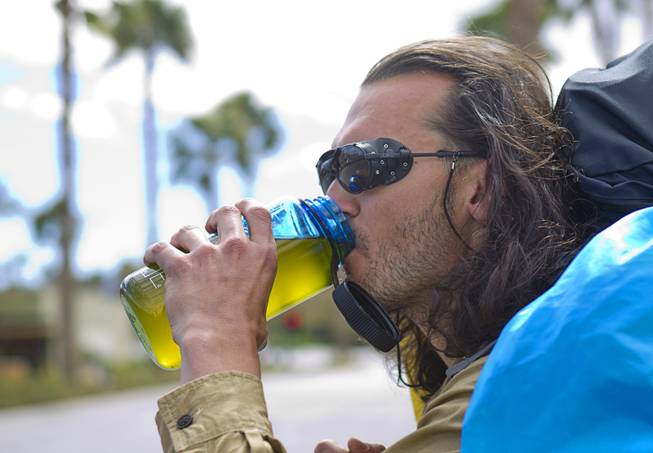 Robert Sorensen, 27, stops for a drink as he heads out for a walk from Henderson to Israel Monday, March 10, 2014. Sorensen said he is not a religious man but that it was a "spiritual" journey. Sorensen estimated the trip to be 16,500 miles.