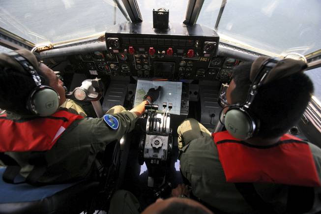 Indonesian navy pilots Maj. Bambang Edi Saputro, left, and 2nd Lt. Tri Laksono check their map during a search operation for the missing Malaysian Airlines Boeing 777 over the waters bordering Indonesia, Malaysia and Thailand near the Malacca straits on Monday, March 10, 2014.