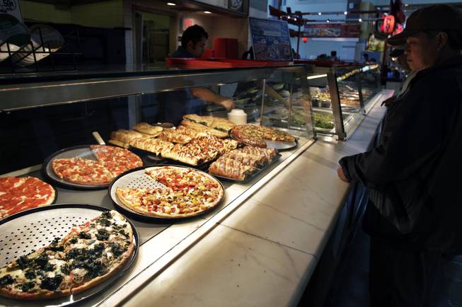 In this April 4, 2011, file photo, a customer looks at pizzas at Sbarro restaurant in San Jose, Calif. Sbarro said Monday, March 10, 2014, that it is filing for Chapter 11 reorganization, the struggling pizza chain's second trip through bankruptcy court in less than three years.

