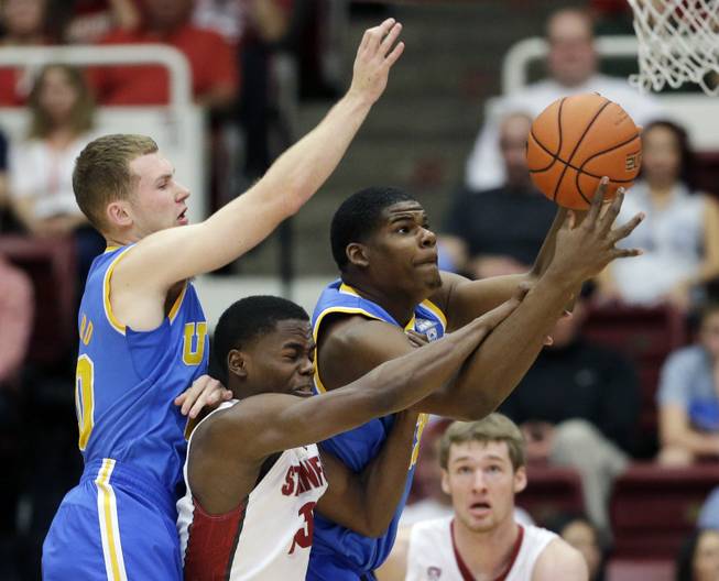 UCLA's Tony Parker, right, grabs a rebound next to Stanford guard Marcus Allen, center, and teammate Bryce Alford, left, during the first half of an NCAA college basketball game on Saturday, Feb. 22, 2014, in Stanford, Calif.