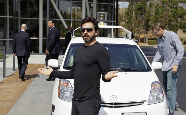 Google co-founder Sergey Brin gestures after riding in a driverless car with California Gov. Edmund G. Brown Jr., left, and state Sen. Alex Padilla, second from left, to a bill signing for driverless cars at Google headquarters in Mountain View, Calif., Sept. 25, 2012.