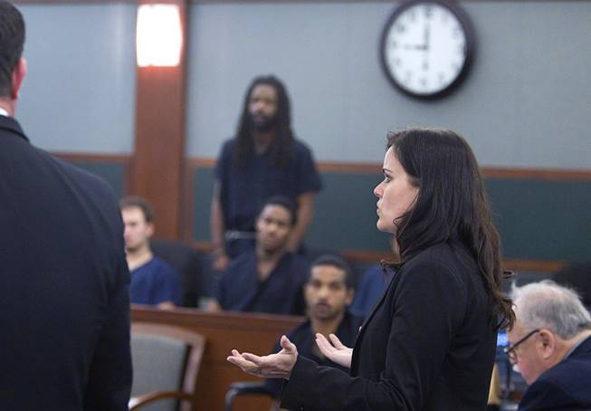Prosecutor Shanon Clowers speaks to Judge David Barker during and arraignment for pet shop owner Gloria Lee and co-defendant Kirk Bills (standing, center) at the Regional Justice Center Wednesday, March 12, 2014. Lee and Bills pleaded not guilty to charges of torching the pet shop where 27 puppies were rescued, and a judge rejected a bid for lower bail.