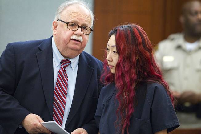 Defense attorney Thomas Pitaro speaks with pet shop owner Gloria Lee at the Regional Justice Center Wednesday, March 12, 2014. Lee and co-defendant Kirk Bills pleaded not guilty to charges of torching the pet shop where 27 puppies were rescued, and a judge rejected a bid for lower bail.