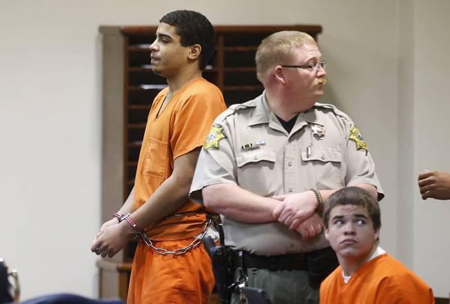In this photo shot through a courtroom door, defendant Chancey Luna, left, is led from the courtroom following a hearing in Duncan, Okla., Wednesday, March 12, 2014. At right is defendant Michael Jones. Both are charged in the murder of Australian Christopher Lane. 